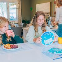 Enfant utilisant la roue des verbes français à la maison